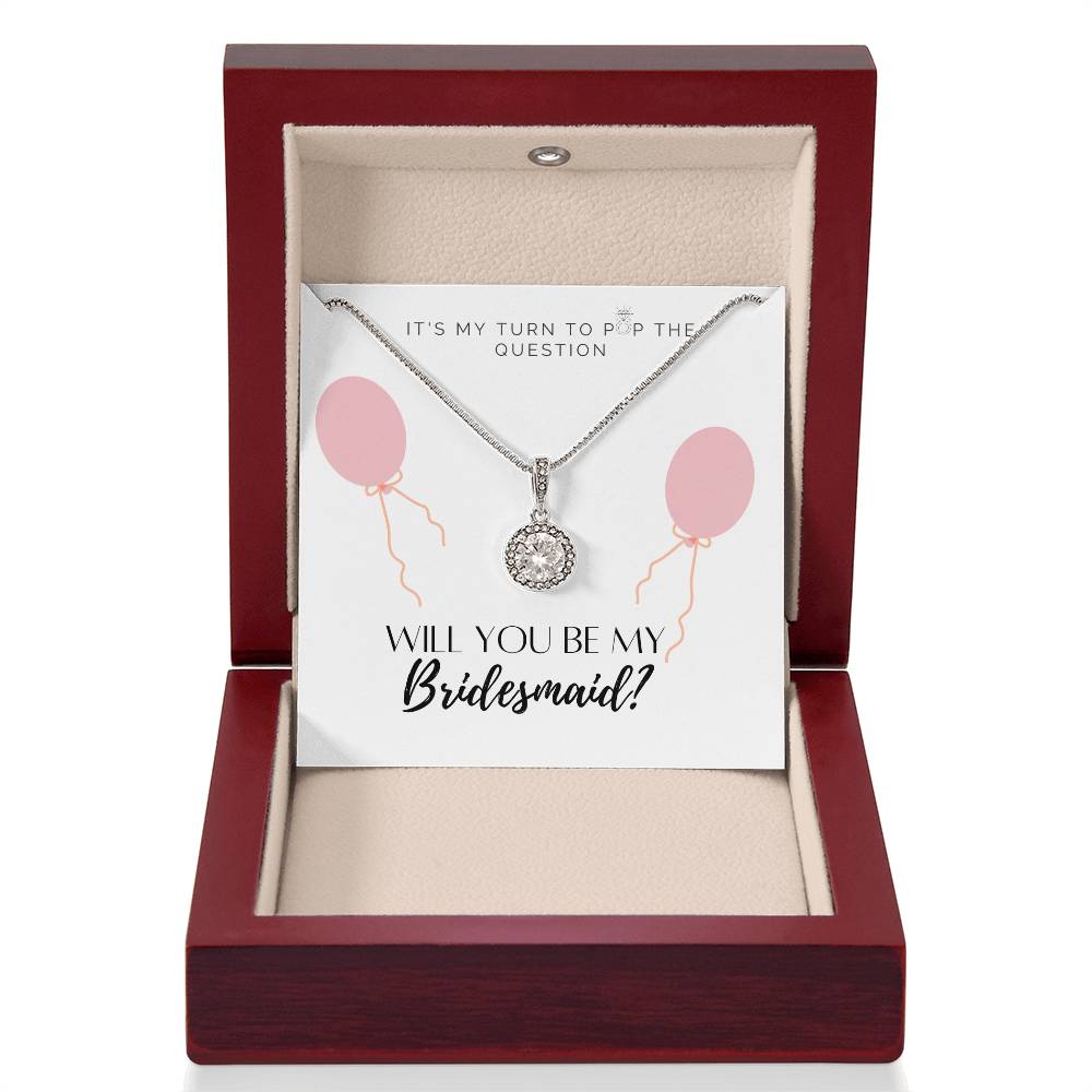 A necklace gift with a big cubic zirconia crystal pendant and a white gold finish, with a message card to bridesmaids, in a mahogany Jewelry box.
