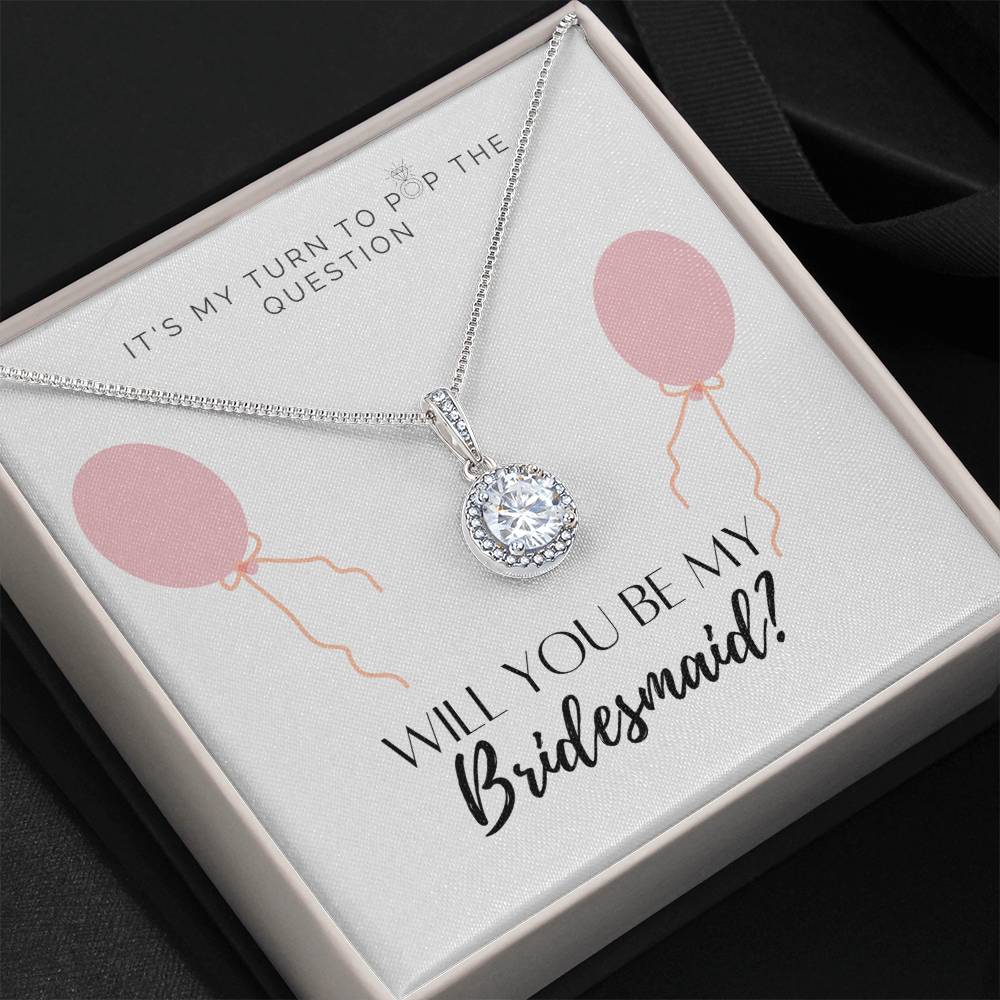 A necklace gift with a big cubic zirconia crystal pendant and a white gold finish, with a message card to bridesmaids, in a Jewelry box.