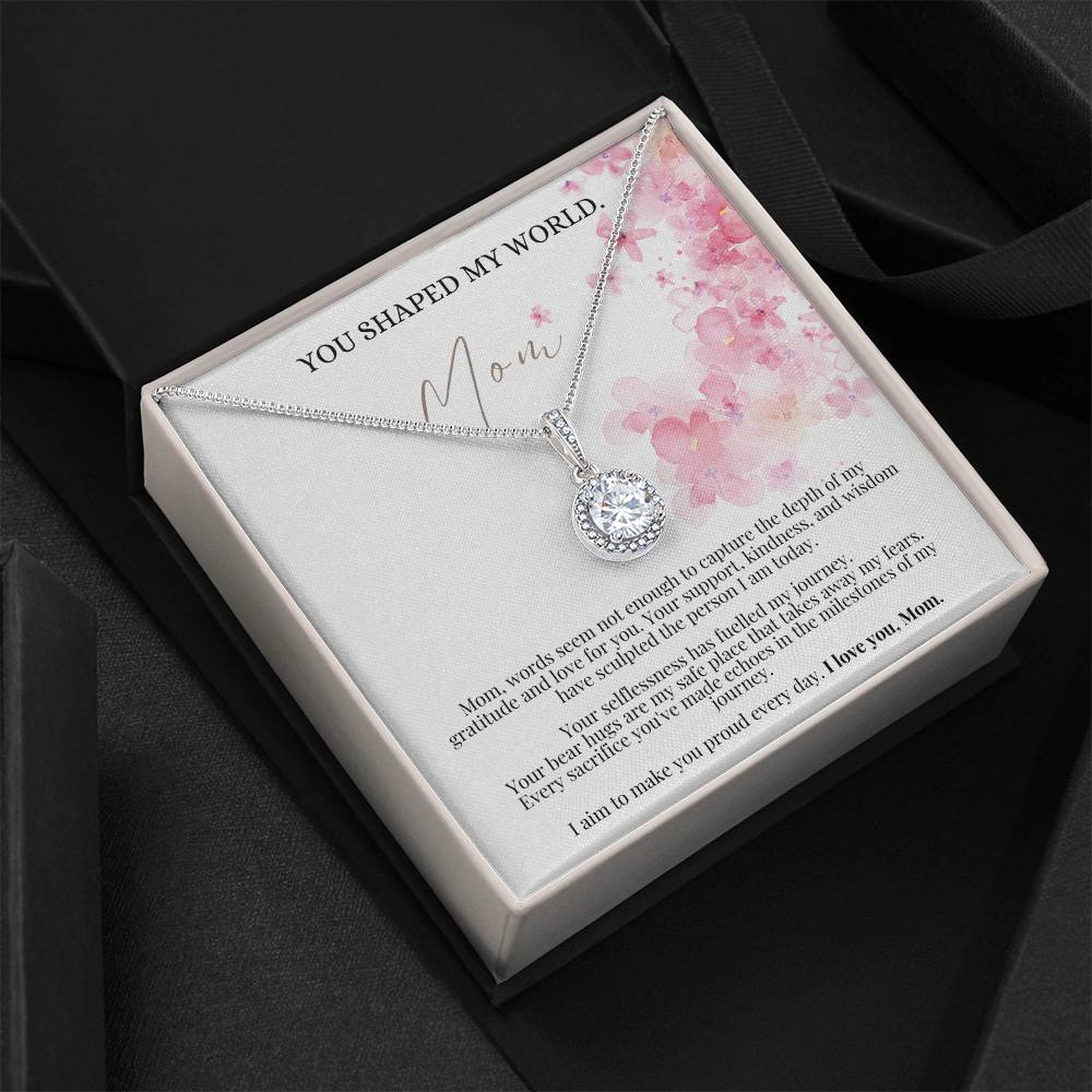 A necklace gift with a big cubic zirconia crystal pendant and a white gold finish, with a message card to mom, in a Jewelry box.