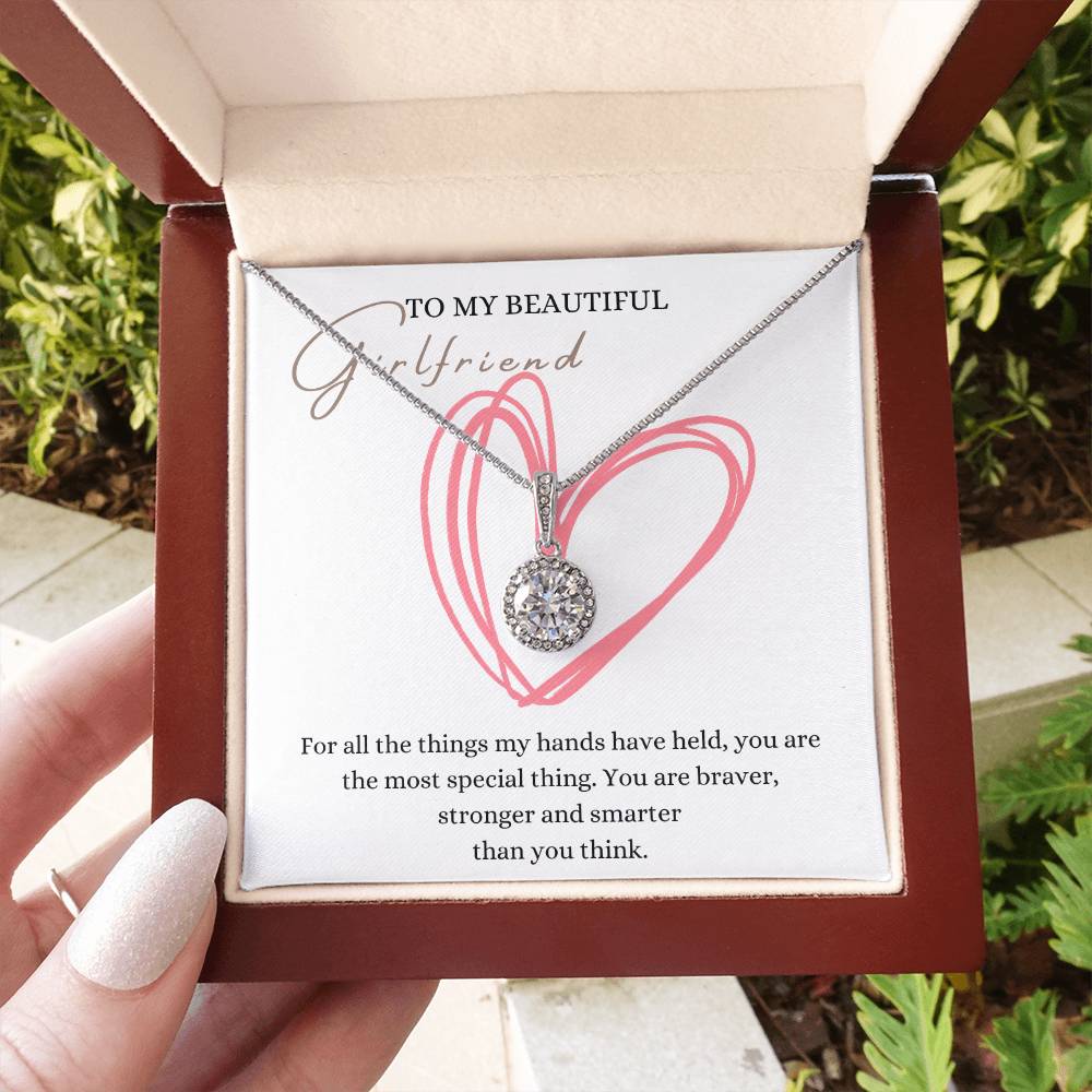 A woman holding a mahogany Jewelry box with a big cubic zirconia crystal pendant and a white gold finish, with a message card to my beautiful girlfriend.