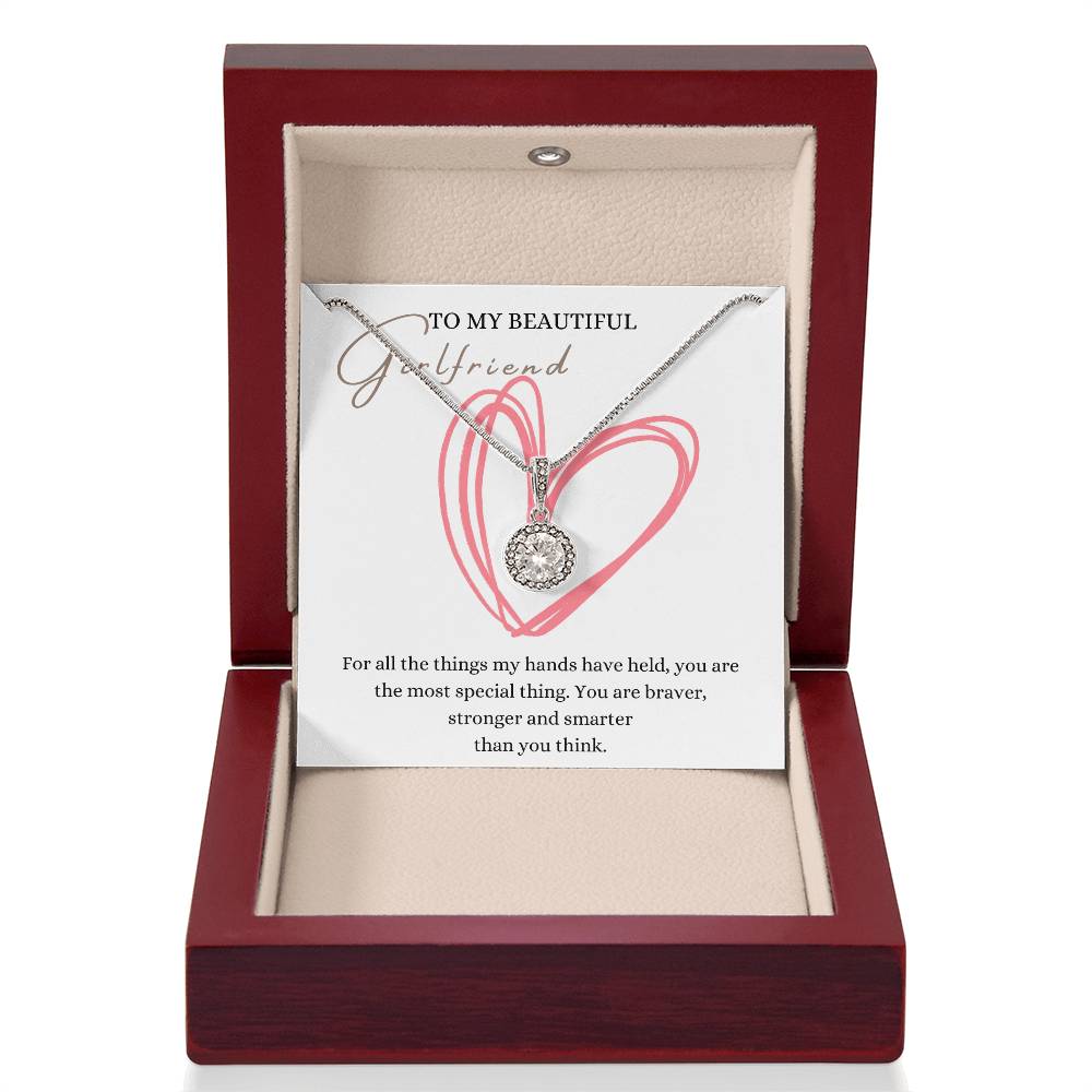 A necklace gift with a big cubic zirconia crystal pendant and a white gold finish, with a message card to my beautiful girlfriend, in a mahogany Jewelry box.