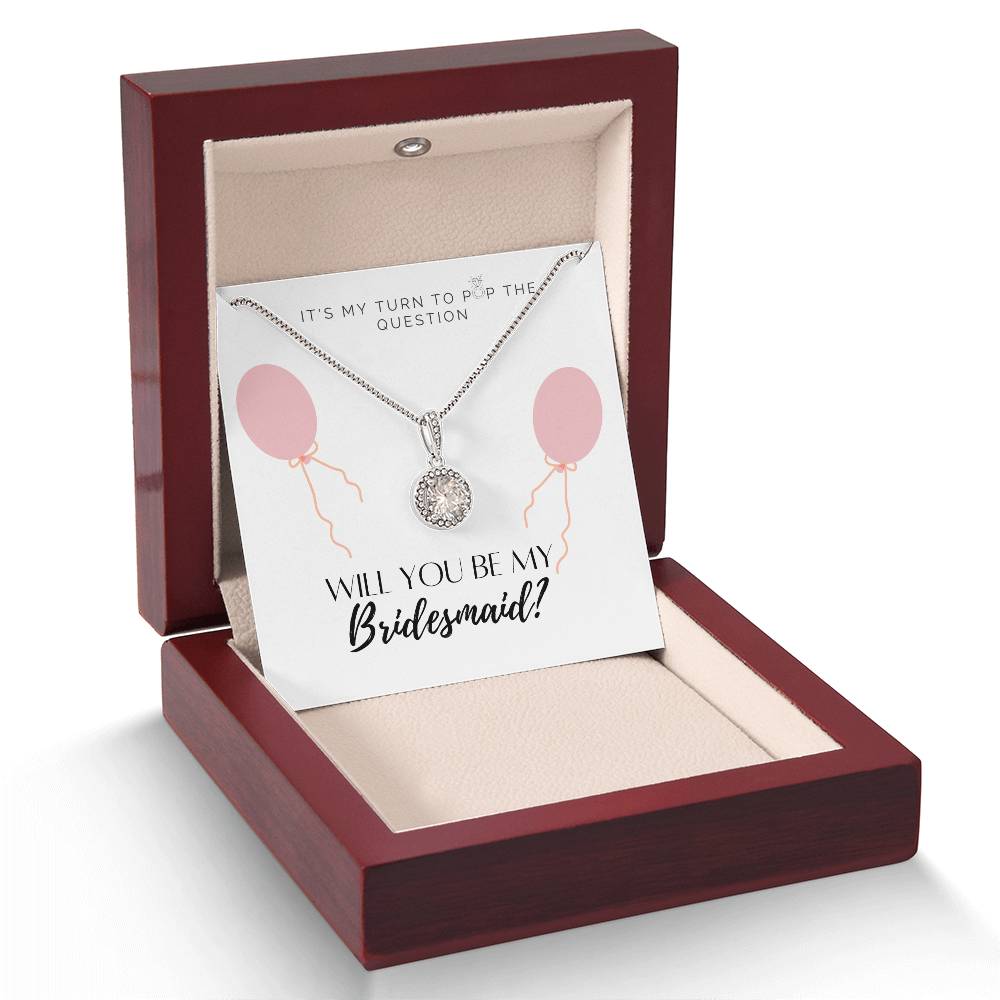 A necklace gift with a big cubic zirconia crystal pendant and a white gold finish, with a message card to bridesmaids, in a mahogany Jewelry box. 