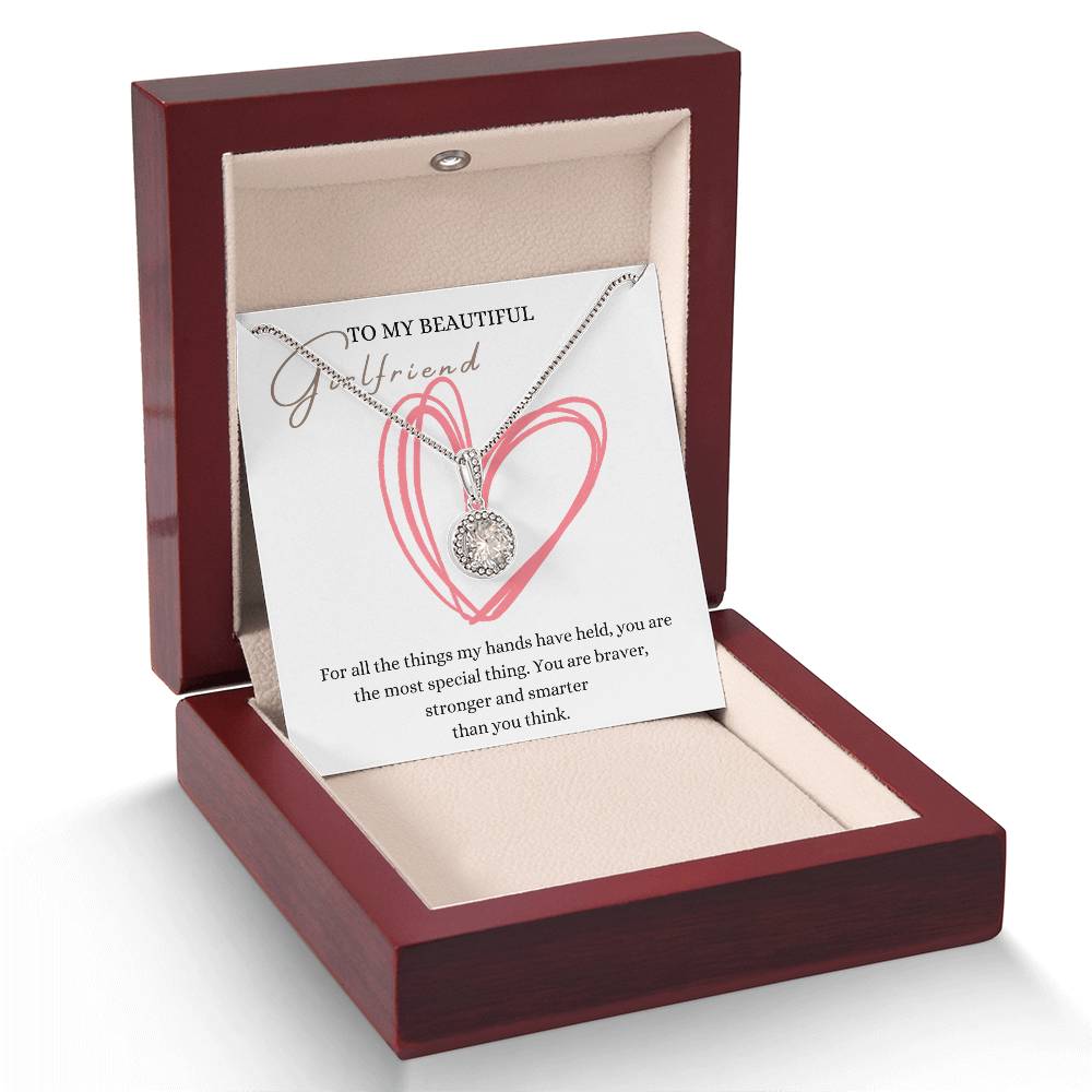 A necklace gift with a big cubic zirconia crystal pendant and a white gold finish, with a message card to my beautiful girlfriend, in a mahogany Jewelry box.