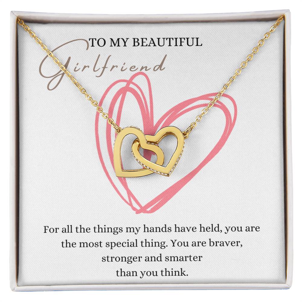 A necklace in a Jewelry gift box, with two connected hearts embellished with cubic zirconia crystals and a gold finish, with a message card to my beautiful girlfriend.