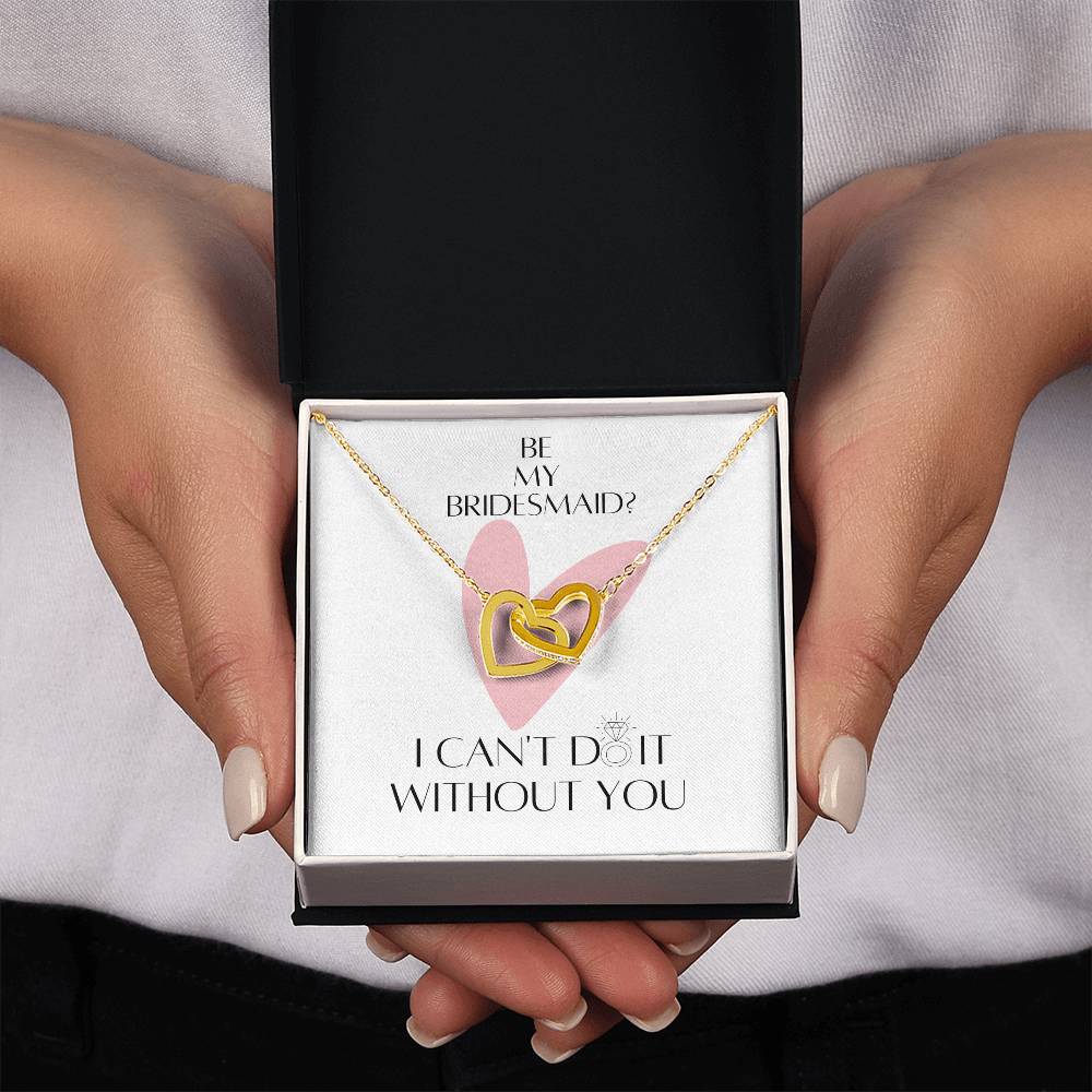 A woman showing a Jewelry gift box with a necklace with two connected hearts embellished with cubic zirconia crystals and gold finish with a message card for bridesmaids.